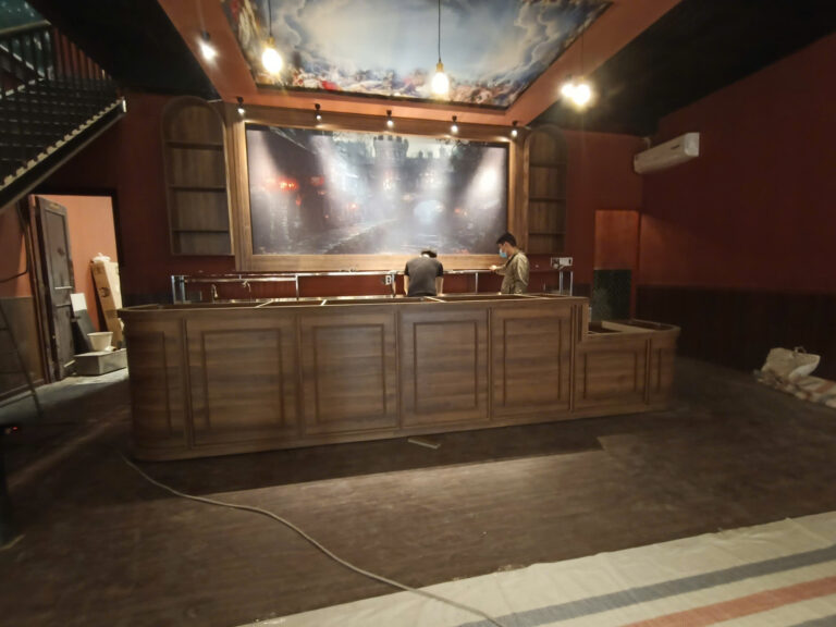 Tổng thể quầy phục vụ tông gỗ với kệ vòm và khung trang trí trong quán cafe Bình Thạnh