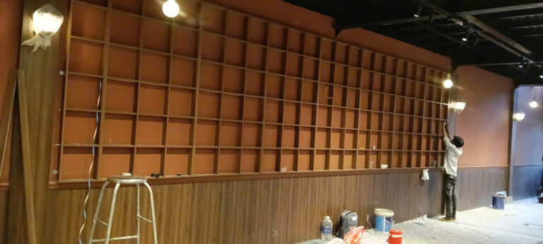 Thợ căn chỉnh hệ kệ chia nhiều ô trên tường quán cafe tại Bình Thạnh
